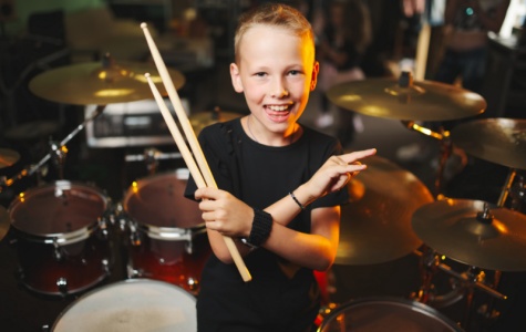 Child holding drumsticks 