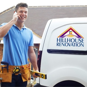Craftsman with tool belt beside a van labeled "Hillhouse Renovation" on the phone, ready for work.